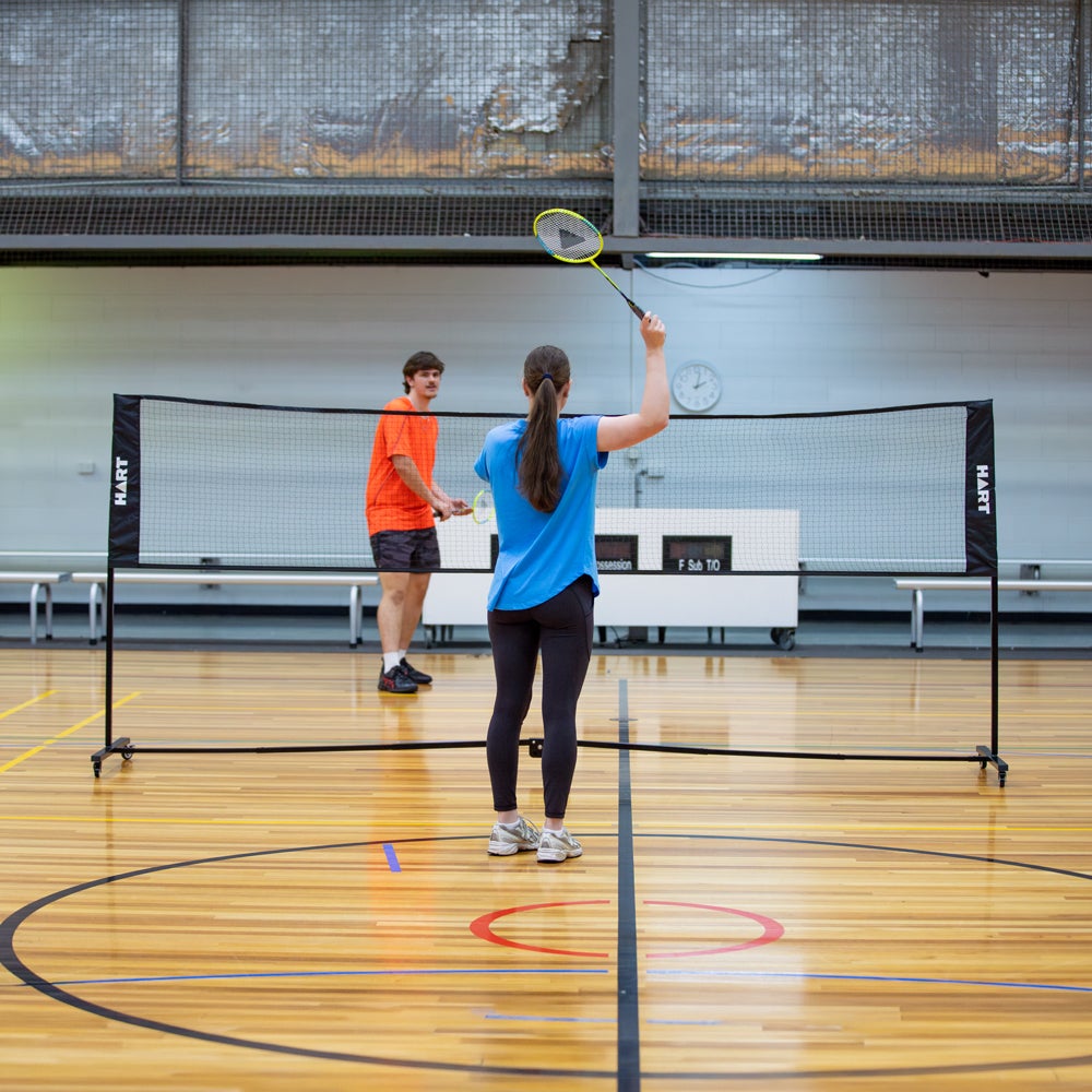 HART Sport rolling net system for badminton with sturdy posts and net, portable design for easy setup and storage.
