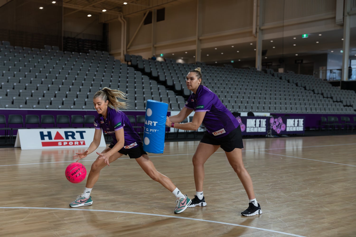 HART Fuse netball in orange and black with Firebirds logo, designed for indoor and outdoor play.